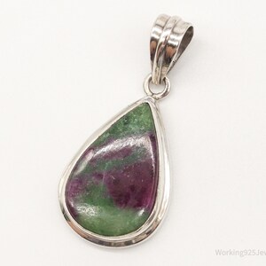 May include: A teardrop-shaped pendant with a green and pink gemstone set in sterling silver.