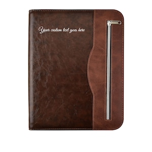 May include: A brown leather portfolio with a zip closure and the text "Your custom text goes here" in a cursive font. The portfolio has a two-tone design, with a darker brown main body and a lighter brown accent on the right side.