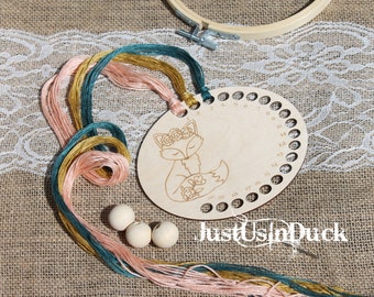 May include: A wooden embroidery floss organizer with a fox design, surrounded by colorful embroidery floss in shades of pink, teal, and gold. Also includes wooden beads and an embroidery hoop. The text "justUsInDuck" is visible.