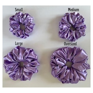 May include: Four purple satin scrunchies in different sizes: small, medium, large, and oversized.
