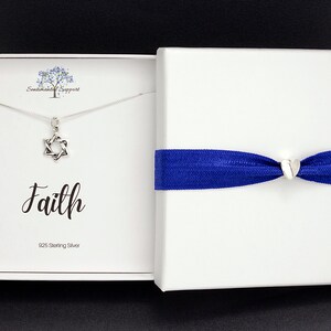 May include: A silver necklace with a Star of David pendant in a white box with a blue ribbon. The box has the word "Faith" written on it and the text "925 Sterling Silver".