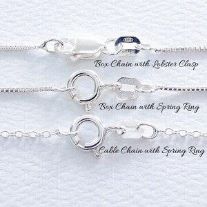 May include: Three silver chains with different clasps. The top chain has a lobster clasp, the middle chain has a spring ring clasp, and the bottom chain has a cable chain with a spring ring clasp.