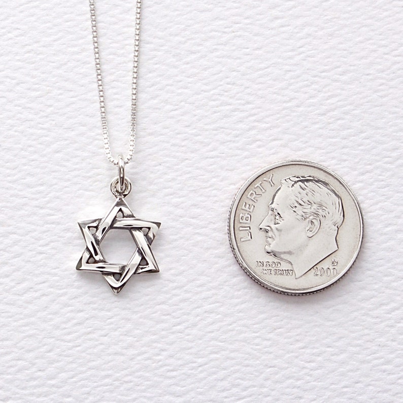 May include: A silver chain necklace with a silver Star of David pendant. The pendant is about the size of a dime.