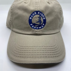 May include: A tan baseball cap with a blue circle logo that says "Blue Ridge Parkway" in white text.