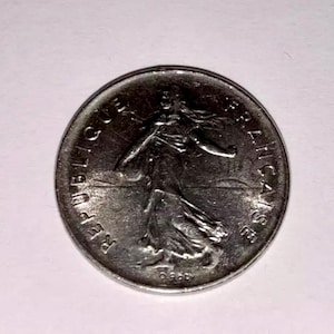 Puede incluir: Una moneda francesa de plata con las palabras "REPUBLIQUE FRANCAISE" alrededor del borde.