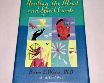 May include: A deck of "Healing the Mind and Spirit Cards" by Brian L. Weiss, M.D. The box is teal and blue, with a grid of colorful illustrations including butterflies, a woman's face, and a flower. The deck contains 50 cards.