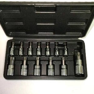 Puede incluir: Una caja de plástico negro que contiene un juego de llaves de vaso Torx cromadas. Las llaves están dispuestas en dos filas, con varios tamaños visibles. La caja está abierta, revelando las herramientas.