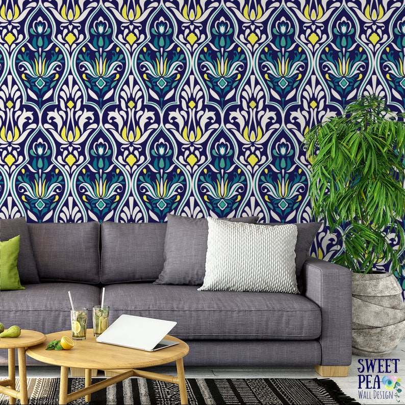 May include: A living room featuring a gray sofa, wooden coffee tables, and a patterned wallpaper. The wallpaper has a repeating design in navy, teal, yellow, and white. A potted plant is in the corner. The room is decorated with a modern style.