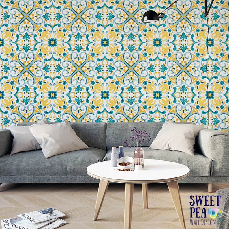 May include: A teal, yellow, and white patterned wallpaper with a geometric design. The wallpaper is shown in a living room setting behind a gray sofa and a white coffee table.
