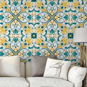 May include: A white couch with two gray pillows and a white pillow with a gray giraffe print. The couch is in front of a wall with a teal and yellow patterned wallpaper.