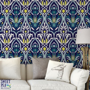 May include: A navy blue and white patterned wallpaper with teal and yellow accents. The design features a repeating floral motif. The wallpaper is installed on a wall behind a white sofa with pillows. The Sweet Pea Wall Design logo is visible.