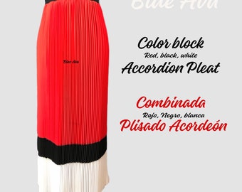 May include: A red, black, and white accordion pleated skirt. The skirt is made of a lightweight fabric and has a high waist. The skirt is called "Combinada" and is described as "Color block, Red, black, white Accordion Pleat".