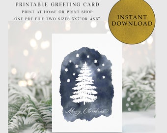 May include: Printable Christmas card featuring a white silhouette of a Christmas tree with stars on a blue watercolor background. The text "Merry Christmas" is written in cursive below the tree.
