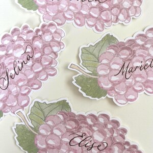 Hand painted and printed watercolour grape place cards with walnut ink personalised calligraphy guest names. Choose from a green bunch of grapes or a purple bunch of grapes. Or have a mix of both colours. Perfect for a Mediterranean wedding, winery event or a party on a vineyard. Classic grape place card are great for a long Italian or Greek lunch under the grapevines.