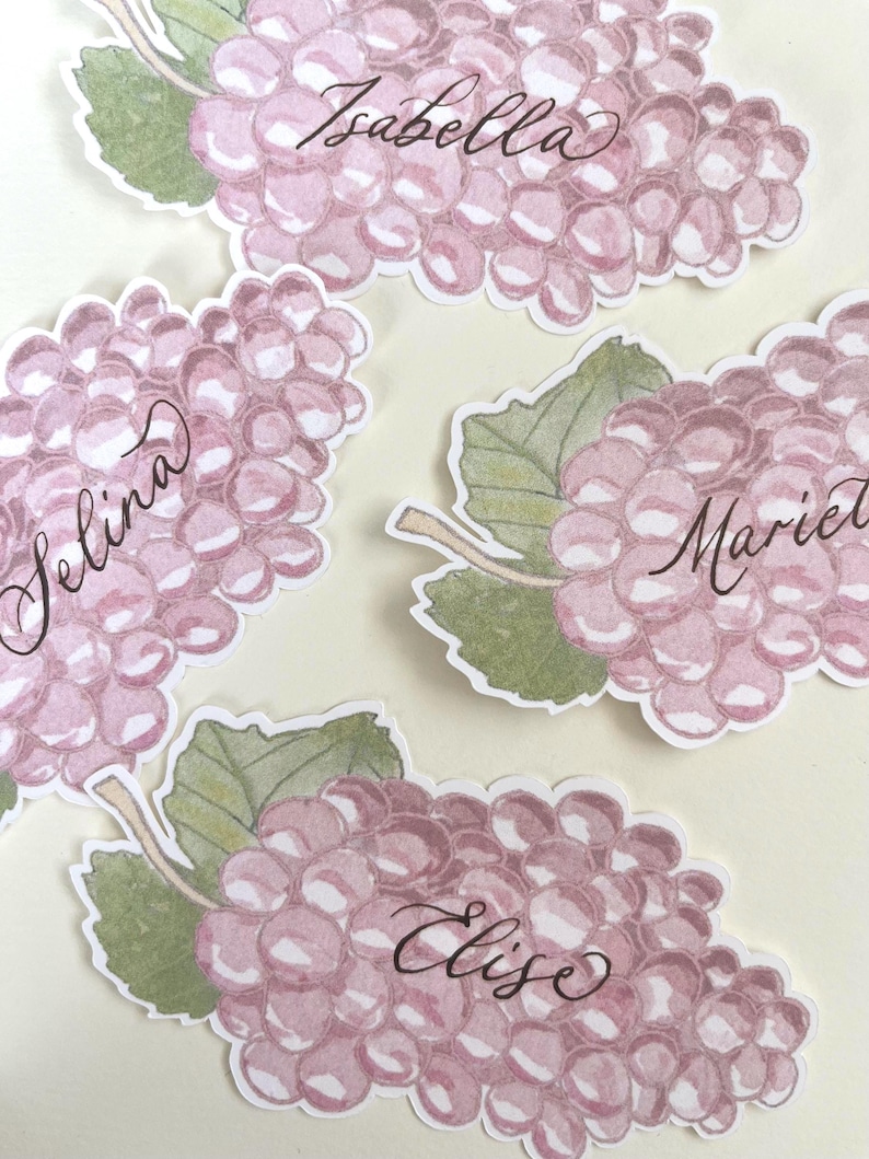 Hand painted and printed watercolour grape place cards with walnut ink personalised calligraphy guest names. Choose from a green bunch of grapes or a purple bunch of grapes. Or have a mix of both colours. Perfect for a Mediterranean wedding, winery event or a party on a vineyard. Classic grape place card are great for a long Italian or Greek lunch under the grapevines.