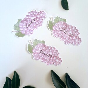 Hand painted and printed watercolour grape place cards with walnut ink personalised calligraphy guest names. Choose from a green bunch of grapes or a purple bunch of grapes. Or have a mix of both colours. Perfect for a Mediterranean wedding, winery event or a party on a vineyard. Classic grape place card are great for a long Italian or Greek lunch under the grapevines.