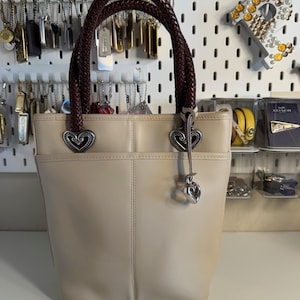 May include: A set of three ceramic mugs with a speckled, matte finish. The mugs are in shades of cream, light gray, and dark gray. Each mug has a simple, modern design and a comfortable handle.