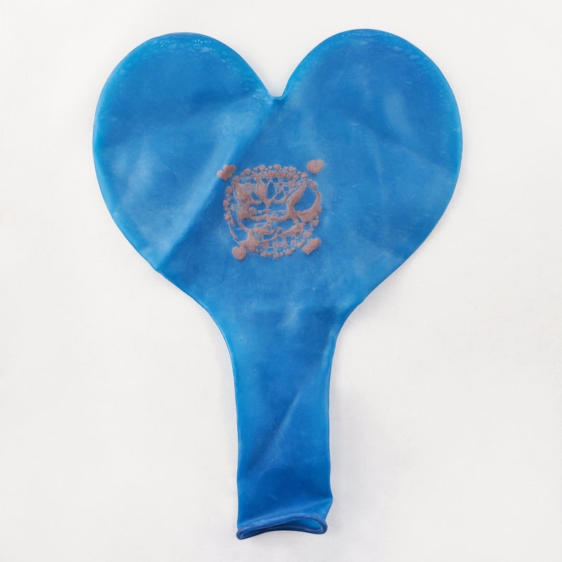 May include: A blue heart-shaped balloon with a faded brown design in the center.