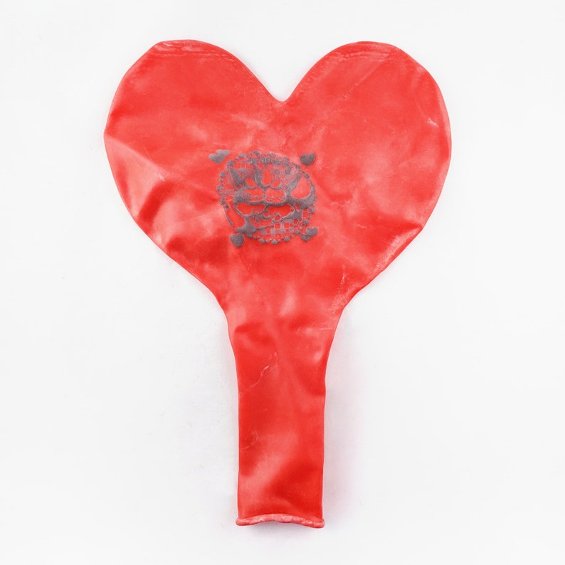 May include: A red heart-shaped balloon with a gray skull and crossbones design.