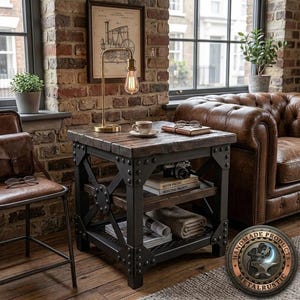 Può includere: Un tavolino quadrato con piano in legno tinto scuro e ripiano inferiore sostenuto da una struttura in metallo nero con rinforzi laterali a X e rivetti decorativi. Il tavolo sostiene una lampada da scrivania in ottone e una tazza in ceramica.
