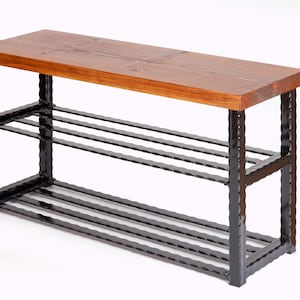May include: A wooden shoe bench with a dark brown, rectangular top and a black metal frame. The bench has three horizontal metal bars for shoe storage. The wood top is a warm brown color.