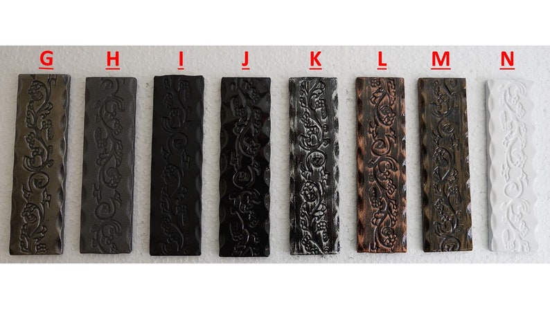 May include: Eight metal strips with a decorative floral pattern in various finishes, including bronze, black, and white.
