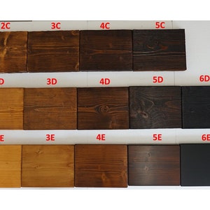 May include: A collection of wooden planks showcasing various stain colors. The samples range from light natural wood tones to dark brown and black, with white options. Each plank is labeled with a code, such as 1C, 2C, and 3C.