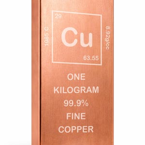 Puede incluir: Una taza de cerámica blanca con un asa negra y el texto "But First, Coffee" en negro y negrita. La taza está sobre una superficie blanca. La taza mide aproximadamente 10 cm de alto.