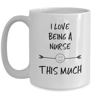 May include: White ceramic coffee mug with a black design that says "I love being a nurse this much" with a smiley face and arrows.