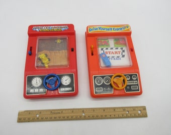 1976 TOMY Monster Maschinen + Fahrer Yourself Crazy - Spiel - Taschen-Handheld Spiel -