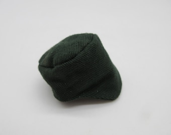 Puede incluir: Una gorra de estilo militar de tela verde oscuro.