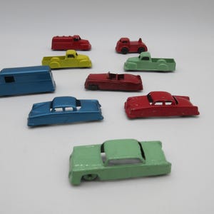 May include: A collection of vintage toy cars in various colors, including red, blue, green, and yellow. The cars are made of metal and have a classic design.
