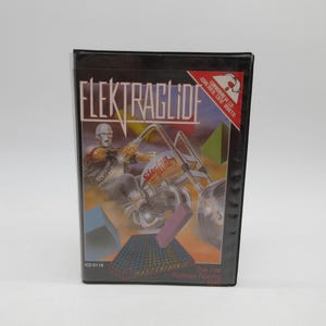 May include: A vintage video game box for "ElektraGlide" featuring a futuristic motorcycle design. The box art includes a rider, geometric shapes, and the game title in a bold font. The game is compatible with Atari and Commodore 64 systems.