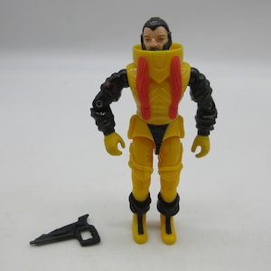 May include: A yellow and black action figure with a red and yellow chest piece. The figure has a black beard and is wearing a yellow helmet. The figure is holding a black gun.