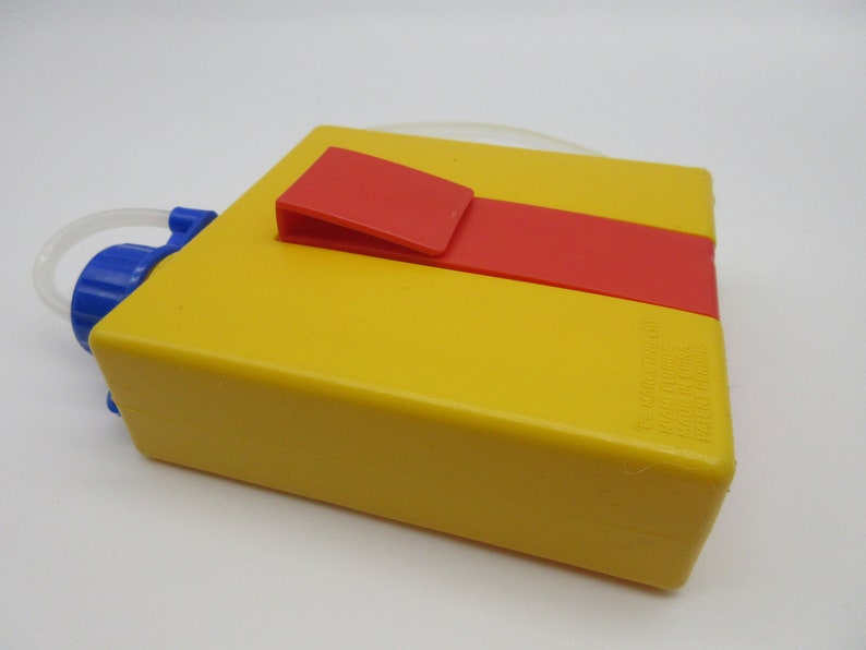 May include: Yellow plastic water bottle with a red and yellow lid and a blue spout. The bottle has a clear plastic tube attached to the spout.