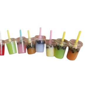 Pu&ograve; includere: Una collezione di mini bevande al t&egrave; alle bolle in vari colori, tra cui verde, rosa e arancione. Ogni bevanda &egrave; in un bicchiere di plastica trasparente con una cannuccia abbinata e perle di tapioca scure.