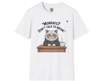 May include: White t-shirt with a grumpy cat graphic and the words "Mondays? Don't talk to meow." The cat is behind a desk with a coffee cup. The shirt has a round neck and short sleeves.