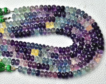 May include: A strand of multi-colored faceted gemstone beads. The beads are a mix of purple, blue, green, and yellow. The beads are strung on a cord with tassels on the ends.