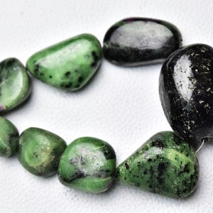 May include: A strand of green and black gemstone beads. The beads are smooth and polished, and they have a natural, organic look. The beads are strung on a thin wire.