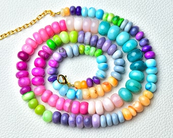 May include: A multi-colored beaded necklace with a gold clasp. The beads are arranged in a rainbow pattern, with pink, purple, blue, green, and orange beads.