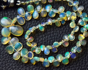 May include: A strand of iridescent opal gemstone beads in a teardrop shape. The beads are strung on a silver wire and have a natural, organic look.