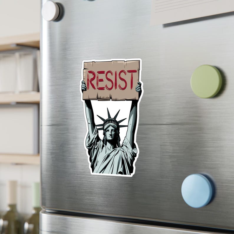 Puede incluir: Una ilustraci&oacute;n de estilo vintage de la Estatua de la Libertad sosteniendo un cartel que dice "RESIST". La estatua est&aacute; representada en un esquema de color azul y gris, con una corona en la cabeza y una antorcha en su mano derecha.
