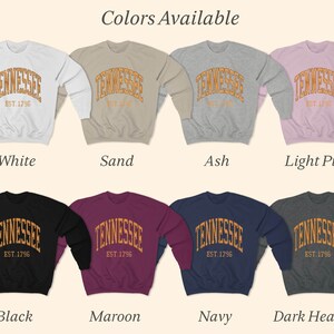 Puede incluir: Una variedad de colores para una sudadera con el texto "Tennessee Est. 1796" en un dise&ntilde;o arqueado. Los colores incluyen blanco, arena, ceniza, rosa claro, negro, granate, azul marino y gris oscuro.