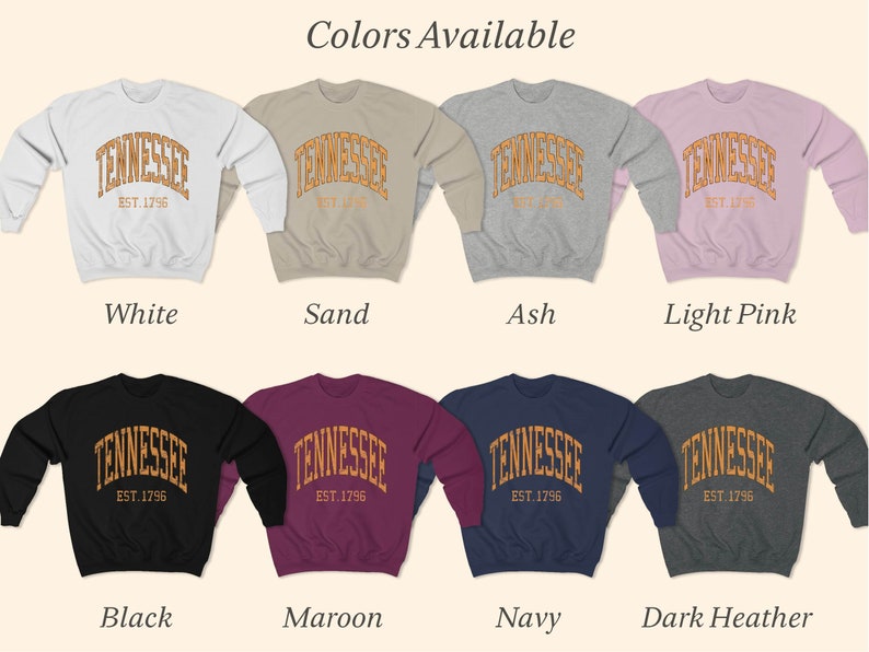 Puede incluir: Una variedad de colores para una sudadera con el texto "Tennessee Est. 1796" en un dise&ntilde;o arqueado. Los colores incluyen blanco, arena, ceniza, rosa claro, negro, granate, azul marino y gris oscuro.