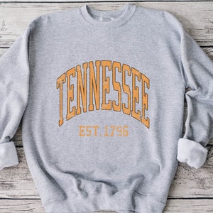 Puede incluir: Sudadera gris con un gr&aacute;fico naranja de estilo vintage que dice "Tennessee Est. 1796".