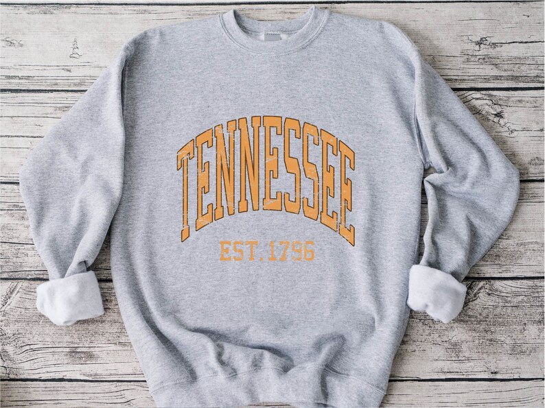 Puede incluir: Sudadera gris con un gr&aacute;fico naranja de estilo vintage que dice "Tennessee Est. 1796".