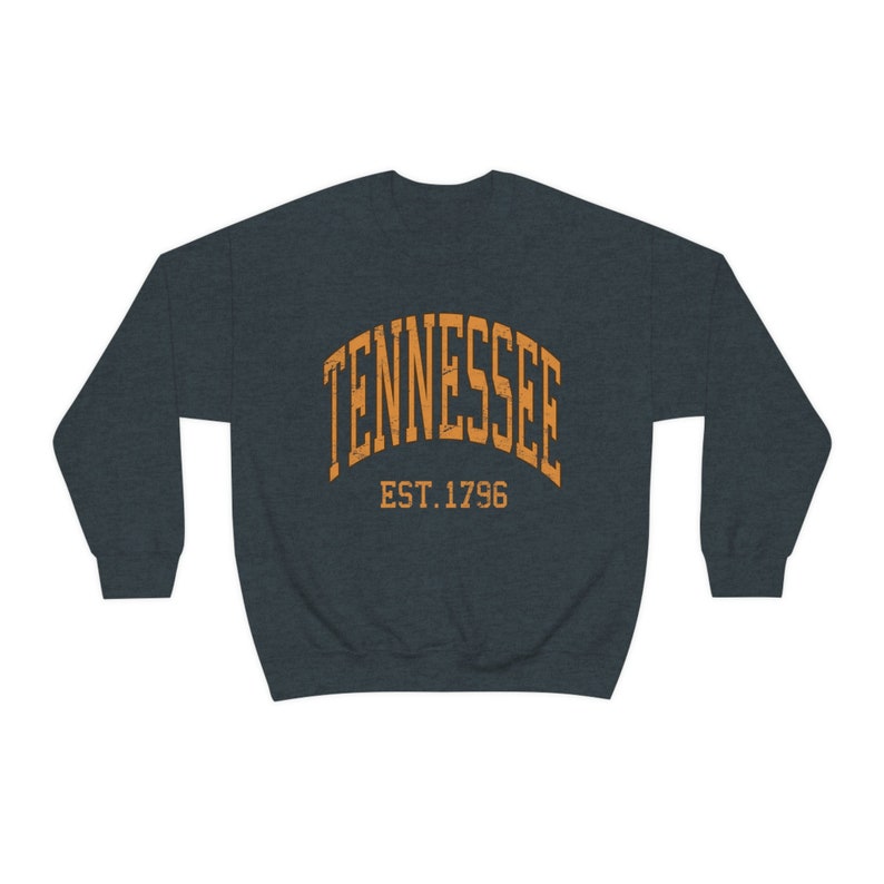 Puede incluir: Una sudadera azul oscuro con un dise&ntilde;o de arco naranja que dice "TENNESSEE EST. 1796".
