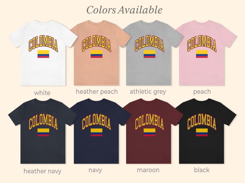 K&ouml;nnte beinhalten: Acht T-Shirts in verschiedenen Farben mit dem Wort "COLOMBIA" in Gelb und einer Grafik der kolumbianischen Flagge. Die Farben sind Wei&szlig;,  Heide-Pfirsich, Athletik-Grau, Pfirsich, Heide-Marine, Marine, Rotbraun und Schwarz.