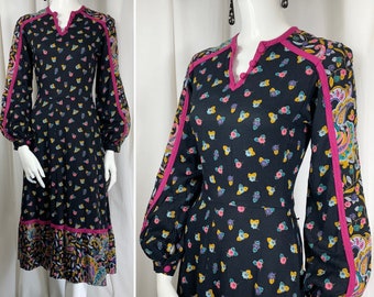 Sukienka z krepy z nadrukiem kwiatowym w stylu paisley z lat 70. Kontrastowe szwy w kolorze magenty z krepy. Rękawy typu balon. Kieszenie. Rozmiary: UK 8-10. Oryginalna, vintage'owa sukienka z lat 70.