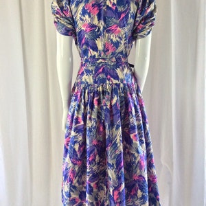 May include: A vintage dress with a floral print in shades of blue, pink, and white. The dress has a fitted bodice and a full skirt.